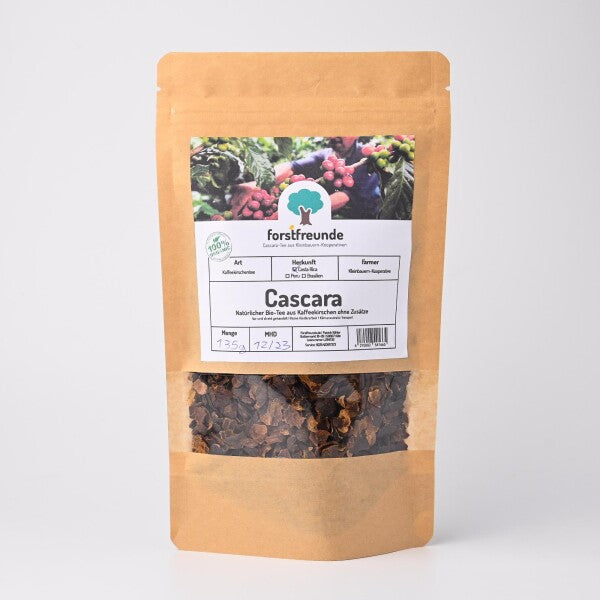 Eine Packung Forstfreunde Bio Cascara, koffeinhaltiger Kaffeekirschentee, in einer braunen Papiertüte mit durchsichtigem Fenster, das die getrockneten Kaffeekirschen zeigt. Die Verpackung trägt ein Etikett mit Informationen zur Herkunft und dem Farmer, der die Kaffeekirschen angebaut hat.