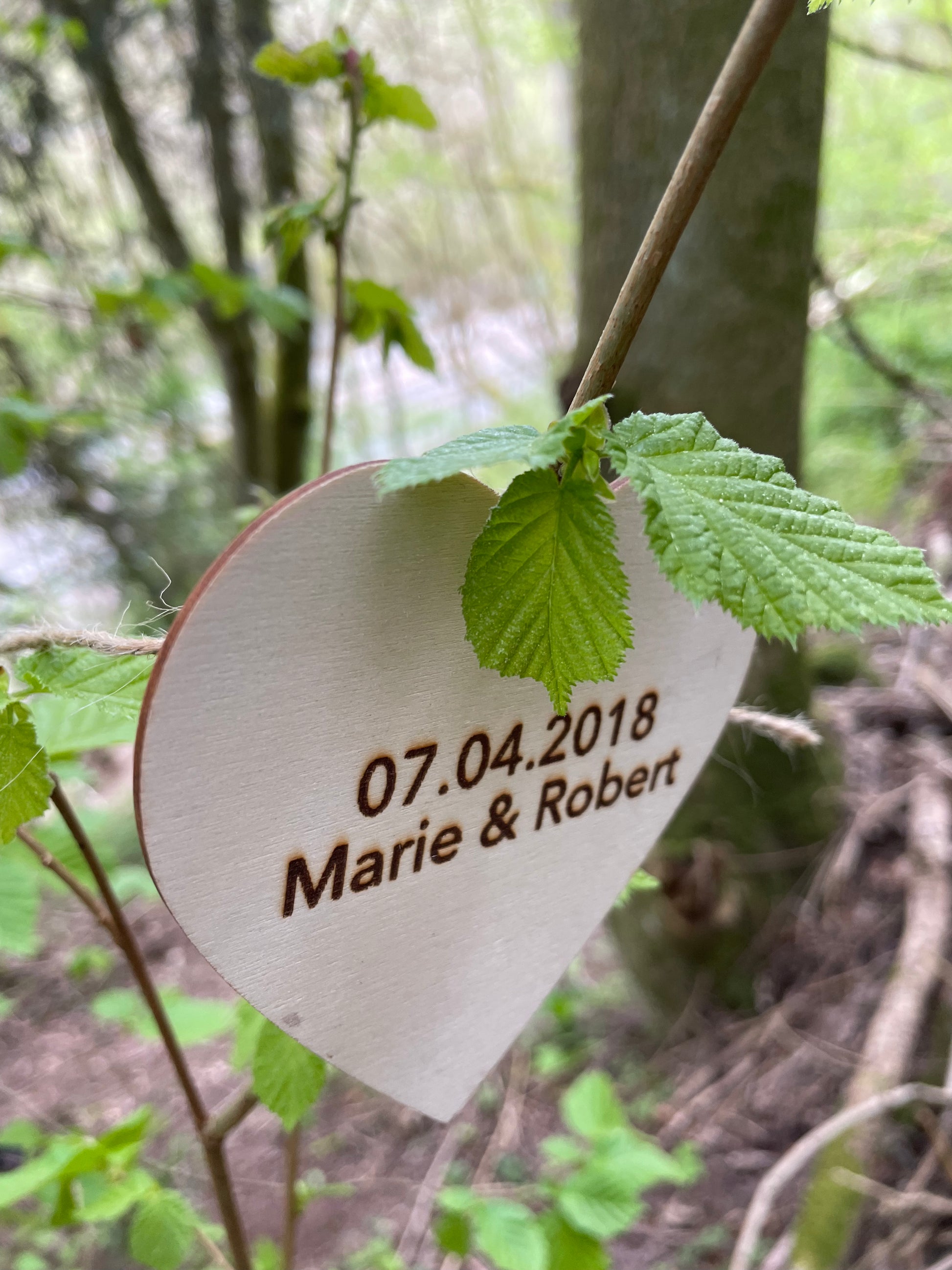 Ein Holzherz aus einer Baumpatenschaft von Forstfreunde mit persönlicher Widmung.