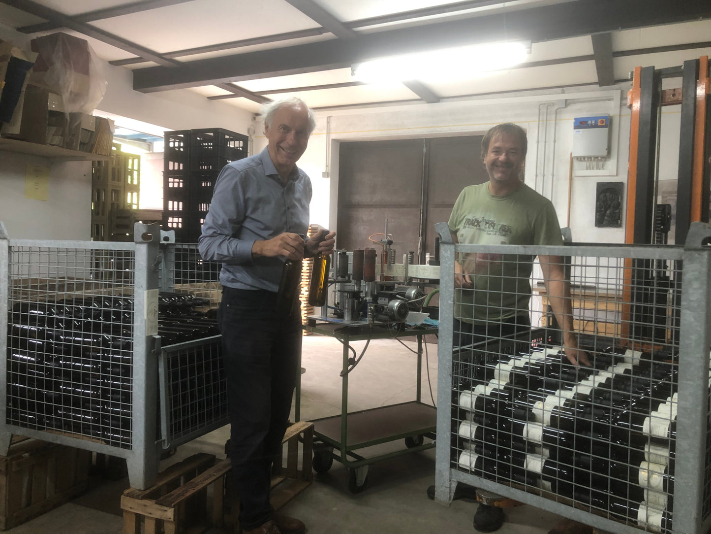 Der Besitzer des Rheinischen Riesling Weinguts füllt zusammen mit seinem Sohn Flaschen ab.