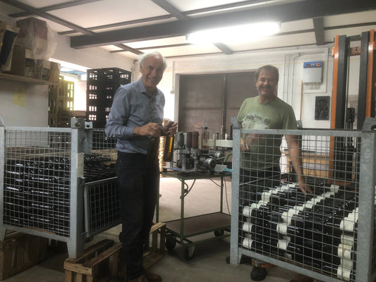 Der Besitzer des Rheinischen Riesling Weinguts füllt zusammen mit seinem Sohn Flaschen ab.